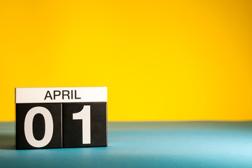 April 1st. Day 1 of april month, calendar on table with yellow background. Spring time, empty space...