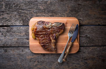 Grilled T-bone steak on wooden board