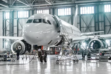 Rolgordijnen Passagiersvliegtuigen voor onderhoud van motor- en rompreparatie in luchthavenhangar. © aapsky