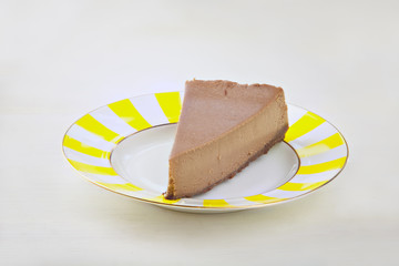 chocolate cheesecake on white plate on  wooden table