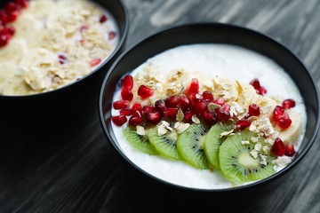 Healthy and tasty low calorie diet meal. Oatmeal and yoghurt smoothie bowl with kiwi slices and pomegranate, delicious and energizing foods for breakfast