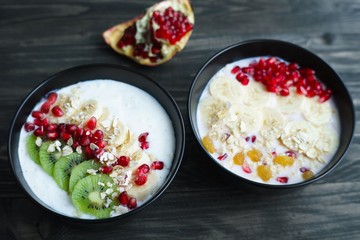 Healthy and tasty low calorie diet meals. Oatmeal and berry yoghurt smoothie bowls with fruit slices and pomegranate, delicious superfoods for breakfast