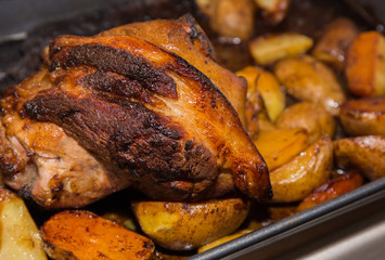oven baked pork leg with potatoes .