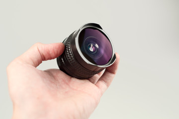 Old lens in hands on a white background