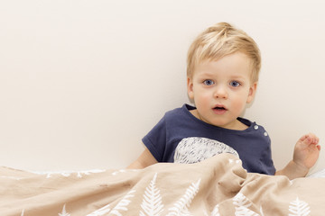 Fototapeta premium Sleepy child in the bed waking up or getting sleep.