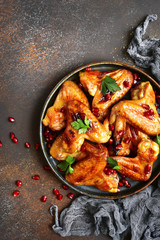 Grilled chicken wings in a honey orange glaze with pomegranate seeds.Top view with copy space.