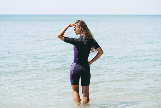 Beautiful Woman In Wetsuit On The Idyllic Beach