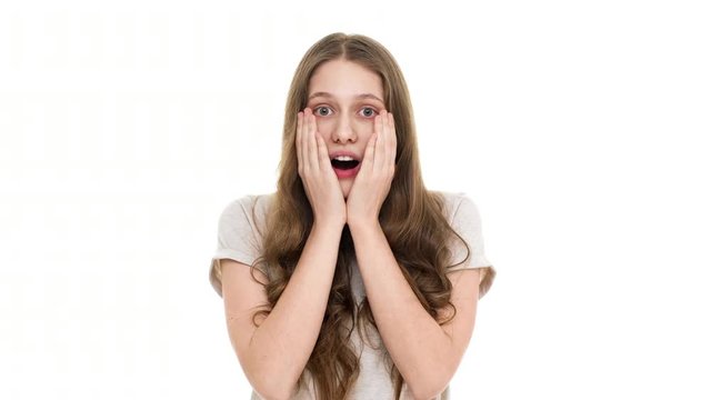 Portrait of young caucasian woman being shocked with unexpected news screaming and covering opened mouth with hands, isolated over white background. Concept of emotions
