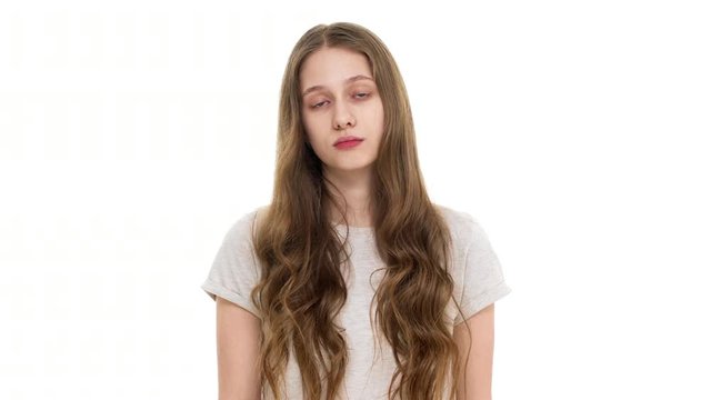 Portrait of serious young woman wearing basic tshirt shaking head in refusal and answering no or dislike, isolated over white background closeup. Concept of emotions