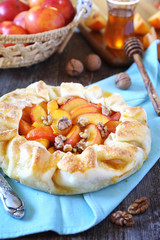 Homemade yellow plums and walnuts tart galette with walnuts and honey