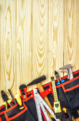 tools in tool belt on wood planks with copy space
