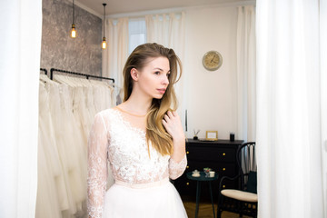 Woman try on wedding bride dress in the fitting room