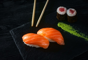two sushi with salmon on stone