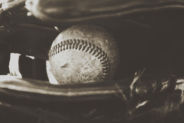Baseball ball in game glove, dirty in monochrome for american sports image.