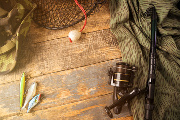 Fishing equipment on wooden desk background.
