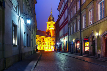 Royal Castle and beautiful street in Old Town during evening blue hour, Warsaw, Poland.