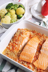 Baked red fish in tomato sauce and fried potatoes with broccoli