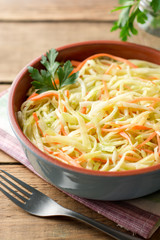 Fresh coleslow salad in bowl on rustic wooden table