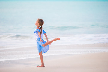 Adorable little girl on the beach. Happy girl enjoy summer vacation background the blue sky and turquoise water in the sea