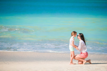 Fototapeta na wymiar Beautiful family of mom and little girl on beach vacation
