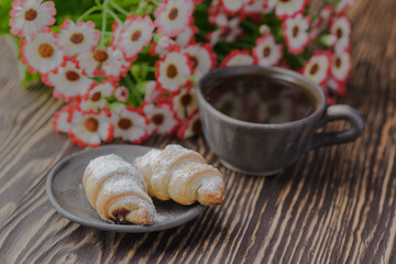 mini croissants on a wooden table,Bagels with a cup of coffee on a wooden table,bagels on a wooden table.
