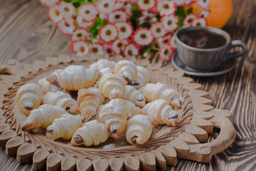 mini croissants on a wooden table,Bagels with a cup of coffee on a wooden table,bagels on a wooden table.