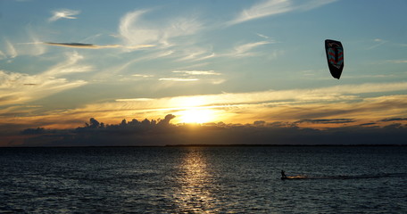 Kiteboarding in sunset on the sea