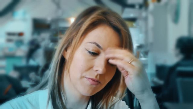 A woman in a cafe looks at the camera and smiles.