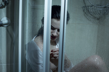 hopelessness stressed young addict woman girl with wet hair and a sad face in bra. concept of domestic violence, early pregnancy soviet bathroom shower in the hostel, a interior of a horror movie