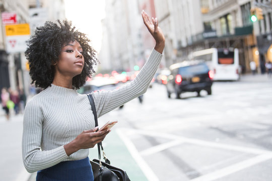 Woman Hailing Taxi Cab Or Ride Share Car Service In New York