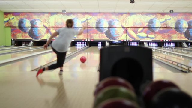 Woman Playing Bowling. Young woman blonde hair playing in a bowling alley