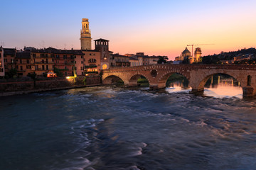 Obraz premium Verona cityscape with Ponte Pietra on Adige river with historical buildings in the evening