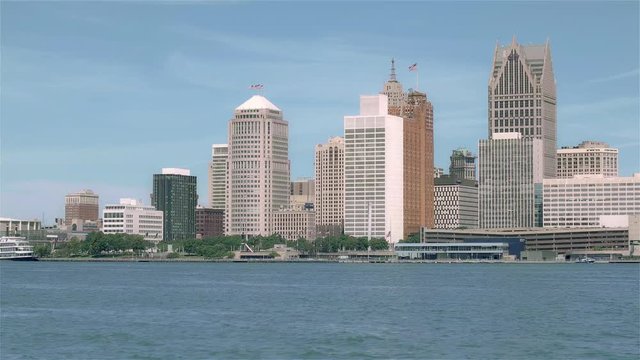 The Renaissance Center and rises above Detroit, Michigan, downtown in summer  with cloud sky