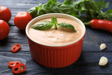 Tasty creamy tomato sauce for fish taco in bowl on wooden table