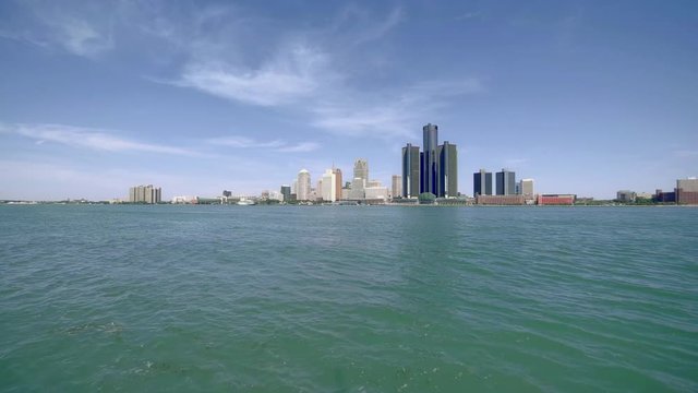 The Renaissance Center and rises above Detroit, Michigan, downtown in summer  with cloud sky