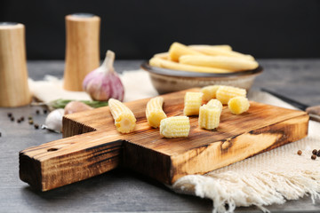 Fototapeta premium Wooden board with fresh young baby corn on table