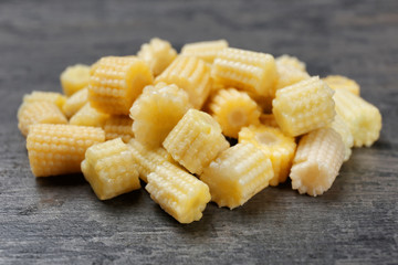 Heap of cut young baby corn on table