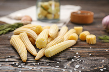 Heap of fresh young baby corn on wooden table