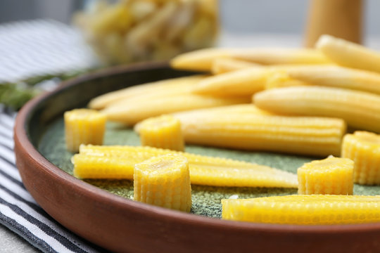 Fresh young baby corn on plate, closeup