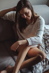 Sexy girl sitting on a sofa and smiling