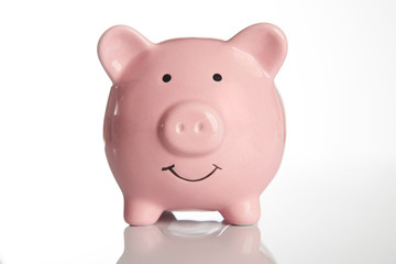 Pink piggy bank isolated on white background with copy space, front view close-up