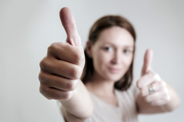 Studio portrait of young woman giving thumbs up