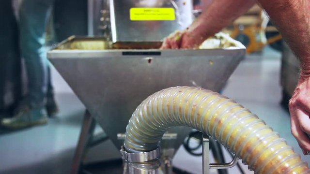 Apple mash in tube at distillery during brandy production