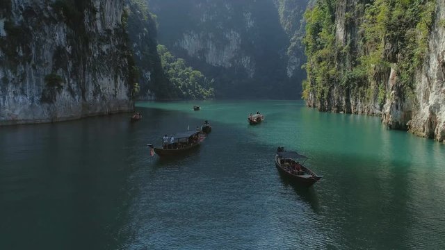 Tropical Thai jungle lake Cheo lan drone flight, wild mountains nature national park ship yacht