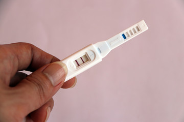 Obraz premium Pregnancy test in hand, two red mark the meaning is pregnant.