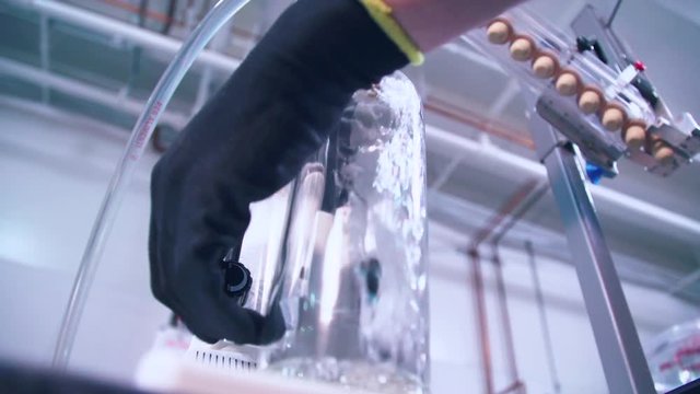 Bottle of clear brandy filling during distillery bottling process