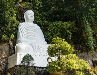 large white marble statue of Buddha outside 