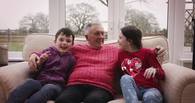 Children enter the frame and sit by grandpa's side