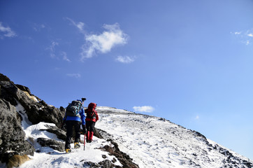 People hiking snowy mountains in winter 
