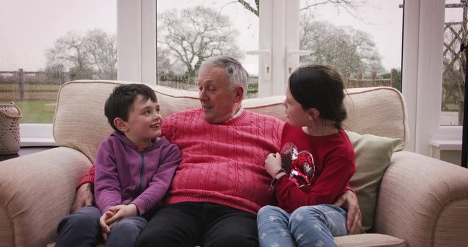 Grandpa tells a story to his grandson and granddaughter